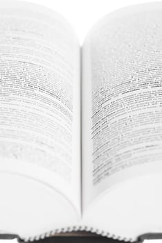 Large book open against white background.