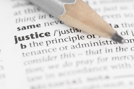 Macro image of dictionary word: Justice, and pencil.