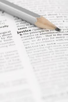 Macro image of dictionary word: Justice, and pencil.