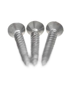 Three new metal screws on white background.