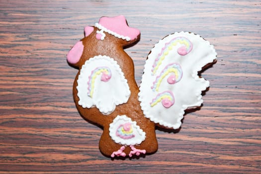 Gingerbread in the form of a cock on a wooden background