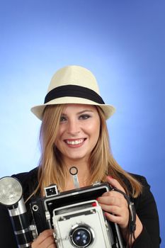 Photo of a beautiful young blond woman holding a vintage 4x5 film camera.
