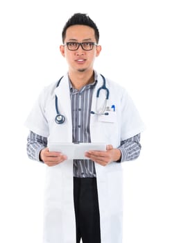 Southeast Asian medical doctor. Serious male medical doctor holding a tablet computer standing on white background.