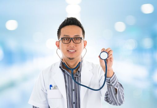 Southeast Asian medical doctor with stethoscope in hand, standing in hospital