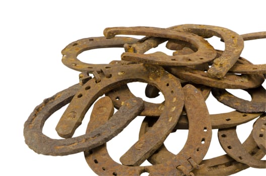 stack of vintage rusty retro horse shoes isolated on white background