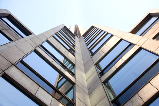 office building with blue sky reflected in windows