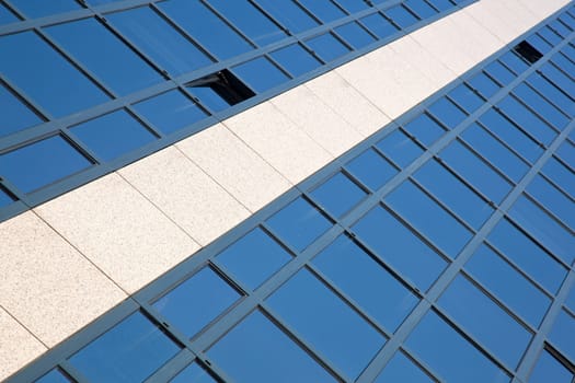 facade of office building with blue sky reflected