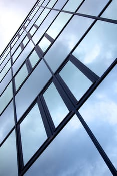 facade of office building with overcast sky reflected