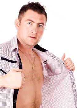 Studio portrait of a serious, muscular young man in profile with his shirt unbuttoned.
