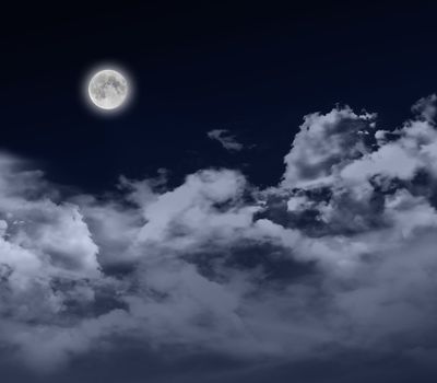 glowing full moon at night with cloudscape