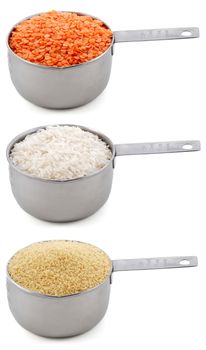 Staple ingredients - lentils, white rice and cous-cous - in cup measures, isolated on a white background