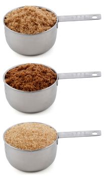 Different sugars - light brown soft or muscovado, dark brown soft or muscovado and demerara - in cup measures, isolated on a white background