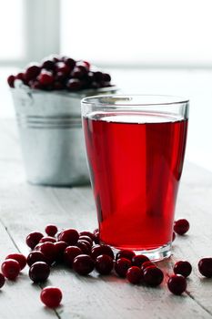 Cranberry juice and berries on a wooden surface