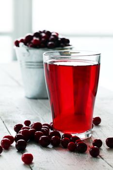 Cranberry juice and berries on a wooden surface