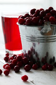 Cranberry juice and berries on a wooden surface