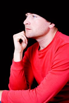 A young man in a black shirt, deep in thought on a white background
