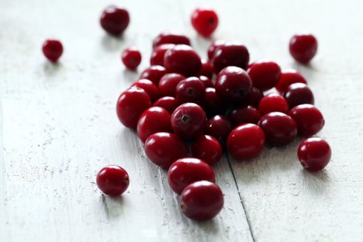 Fresh cranberries on a white wooden surface