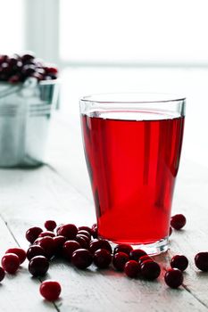 Cranberry juice and berries on a wooden surface