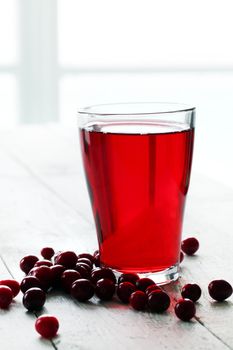 Cranberry juice and berries on a wooden surface