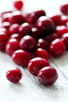 Fresh cranberries on a white wooden surface