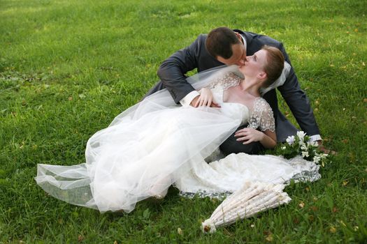 The groom and the bride kiss having closed by a veil