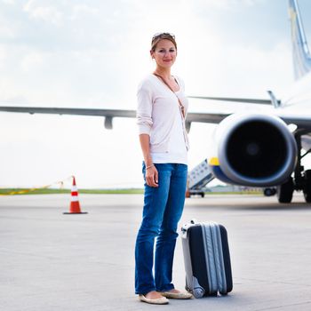 Just arrived: young woman at an airport having just left the aircraft