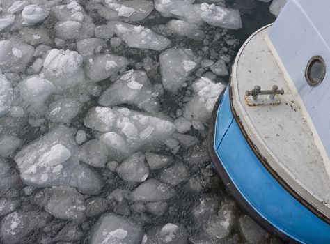Tiny fishing boat caught by the ice in the harbor of Nyborg - Denmark.