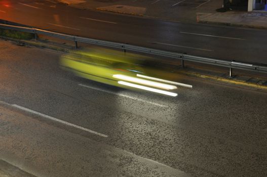 Speeding yellow cab on the motorway city traffic at night. Motion blur.