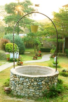 Old Well with a bucket in beautiful garden