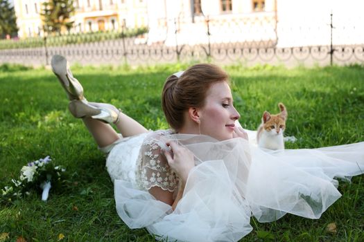 Beautiful bride and kitten in park