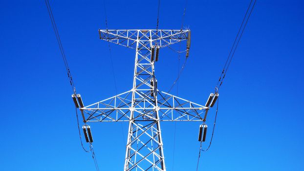 High voltage transmission lines against blue sky