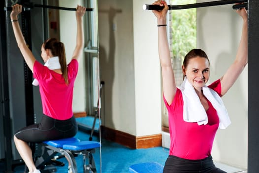 Cute smiling female working out, looking at you