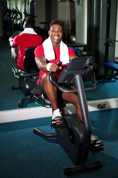 Young guy burning calories, pedaling fast on the exercise bike