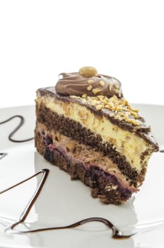 Chocolate cake with hazelnuts served on a decorated plate.