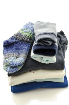 A stack of baby clothes with socks isolated on a white background.