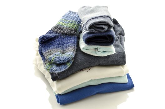 A stack of baby clothes with socks isolated on a white background.