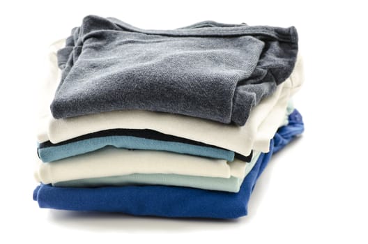 A stack of baby boy clothes isolated on a white background.