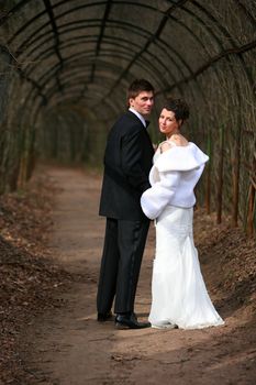 The groom and the bride walk in park.