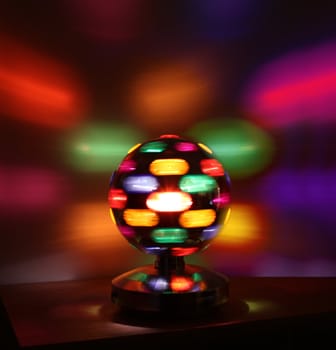 Colorful disco lights ball rotating reflections on wall