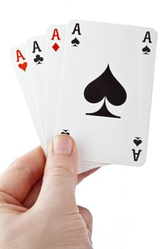 Hand holding four aces over a white background.