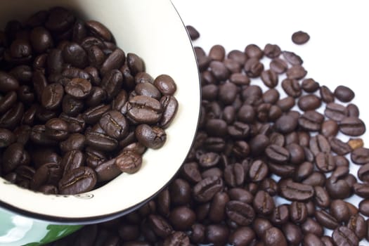 Black coffee beans in bowl on white background