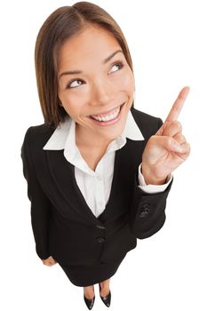 Business woman pointing showing and looking to the side up at empty copyspace. Multi ethnic Asian Chinese / Caucasian female businesswoman standing isolated on white background in full body length.