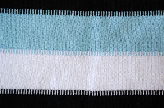 background of pullover ornament pattern. white black blue horizontal colors texture lines closeup.