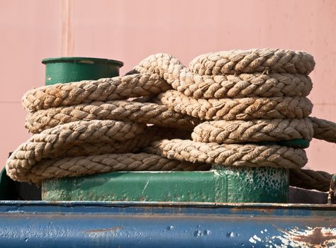 green mooring bollard and bundle of rope