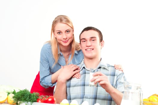 wife embraces the husband, he holds a glass of milk