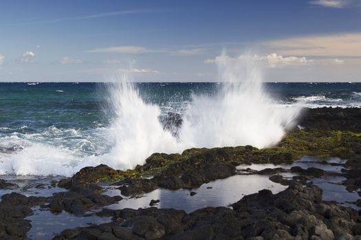 wave crashing against rocks on the island of Oahu