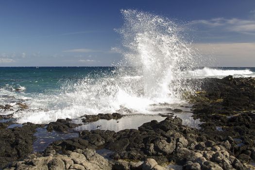 wave crashing against rocks on the island of Oahu