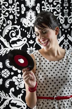 young woman laughing a the label of a small record