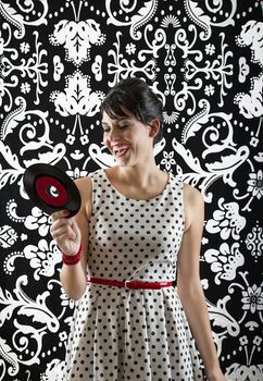 young woman smiling a the label of a small record