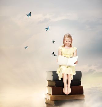 Little Blonde Girl Reading a Book  on Top of Books